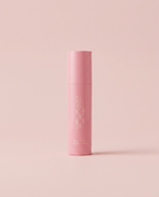 PDRN Collagen Glow Balm pink stick on a soft blush pink studio background
