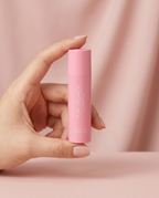 Hand holding the PDRN Collagen Glow Balm stick showing its true handbag size